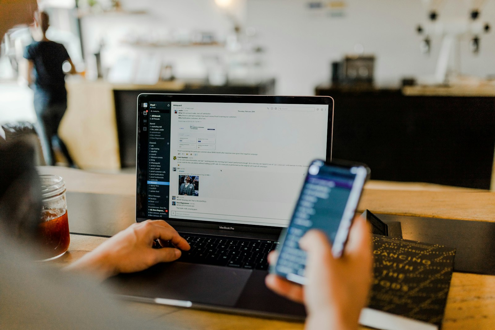 Remote employee working at a home desk with a phone and laptop covered by a stipend