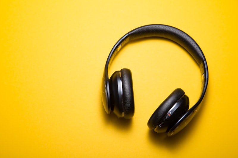 Noise-cancelling headphones on a clean desk next to a laptop and coffee