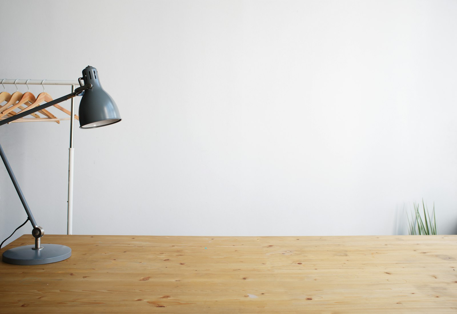 Balanced-arm desk lamp on a wooden desk providing task lighting