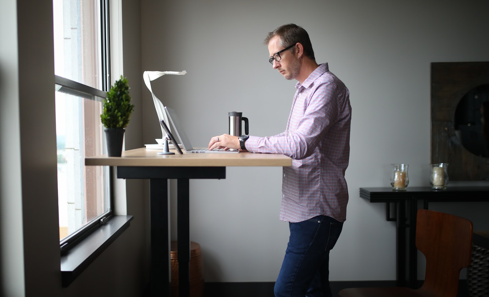 Person working at a raised standing desk in a home office